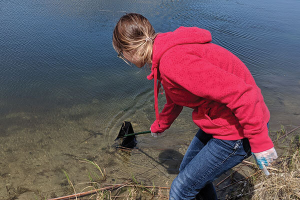 what_we_do_scooping_sample_of_water